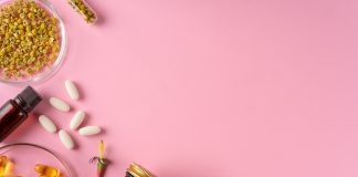 Compléments Alimentaires : Bienfaits et Risques Compléments alimentaires : flacons, pilules et herbes sur fond rose, vitamines et minéraux pour la santé.