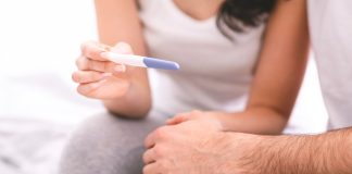 Tout Savoir sur l’Infertilité : Symptômes et Traitements Couple regardant un test de grossesse, moment intime et émouvant, espoir de fertilité et parentalité