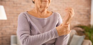 Ostéoporose : Symptômes, Causes et Traitement Femme âgée souffrant de douleurs au poignet, symptôme possible d'ostéoporose et de fragilité osseuse