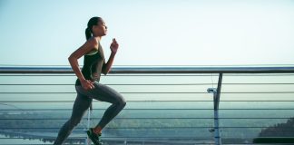 Entraînement au Semi-Marathon : Intermédiaire 2 Coureuse s'entraînant pour un semi-marathon sur une terrasse panoramique au lever du soleil