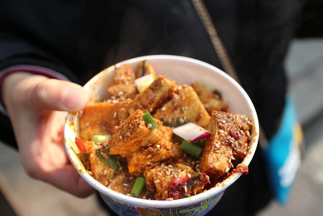 Bol de tofu croustillant aux sésames avec légumes frais, servi dans un plat à emporter - recette santé végétarienne riche en protéines