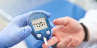 14 façons simples de réduire naturellement la glycémie Un professionnel de santé portant des gants bleus effectue un test de glycémie sur un patient à l'aide d'un glucomètre numérique affichant une valeur de 139 mg/dL. Ce test est essentiel pour le suivi et la gestion du diabète.