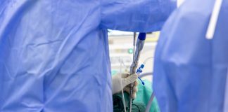 Les injections péridurales : Types, Durée et Effets secondaires Professionnel de santé en tenue bleue effectuant une procédure d'anesthésie péridurale avec cathéter sur un patient