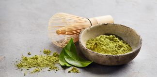 Matcha : Ce que c’est et comment l’utiliser Poudre de matcha vert vibrant dans un bol traditionnel avec fouet en bambou chasen et feuilles de thé frais - ingrédients pour préparer un authentique thé matcha japonais