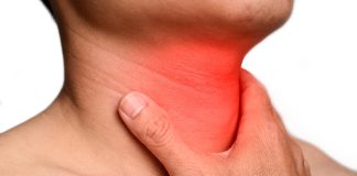 Amygdalite : Symptômes, Causes et Traitement Inflammation de la gorge rouge indiquant une amygdalite ou pharyngite, avec une main touchant la zone douloureuse du cou