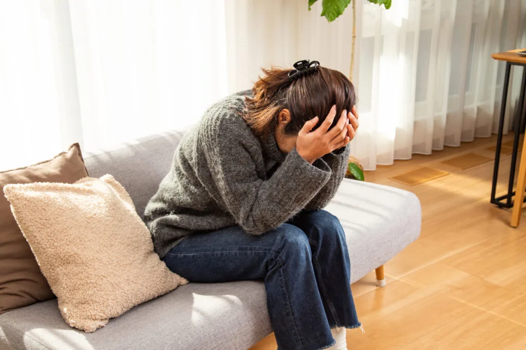 Image d’une femme affichant une expression de tristesse, illustrant les effets émotionnels de la dépression post-partum après l’accouchement.